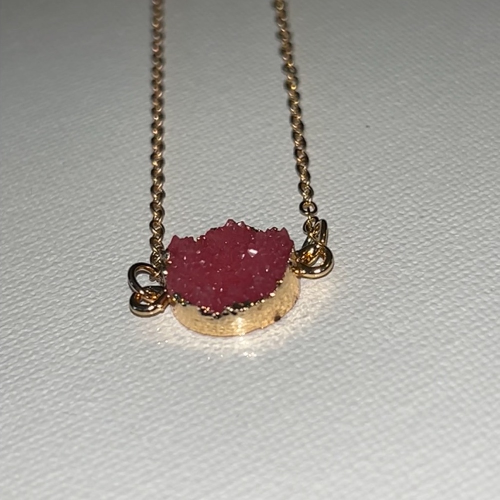 Shine bright with this stunning gold necklace featuring a beautiful pink crystal